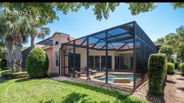 Een modern huis met een glazen patio en een zwembad.