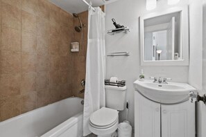 A bathroom with a bathtub, toilet, and sink. - Pool/StepsToBeach/Dine/MoodStudioCONDO (Palm Beach)