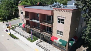 A multi-story building with balconies, a pizza restaurant, and a visible storefront. - 2 Bedroom Apartment Downtown Sun Prairie! (Sun Prairie)