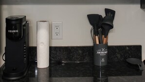 A kitchen with white shelves holding various dishes and a coffee maker on the counter. - 2 Bedroom Apartment Downtown Sun Prairie! (Sun Prairie)