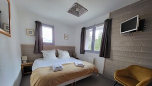 A hotel room with a bed, a chair, a TV, and two windows with curtains. - Chalet Courchevel - 14 Persons, 7 Bedrooms 7 Bathrooms, 40m from slopes (Courchevel)
