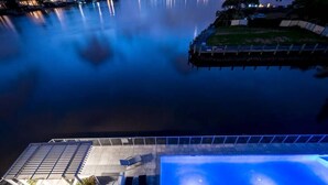 Una piscina con vistas a un cuerpo de agua tranquilo y un muelle.