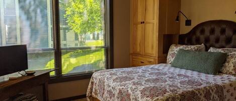 Ein Schlafzimmer mit Bett, Holzschrank und Deckenventilator.