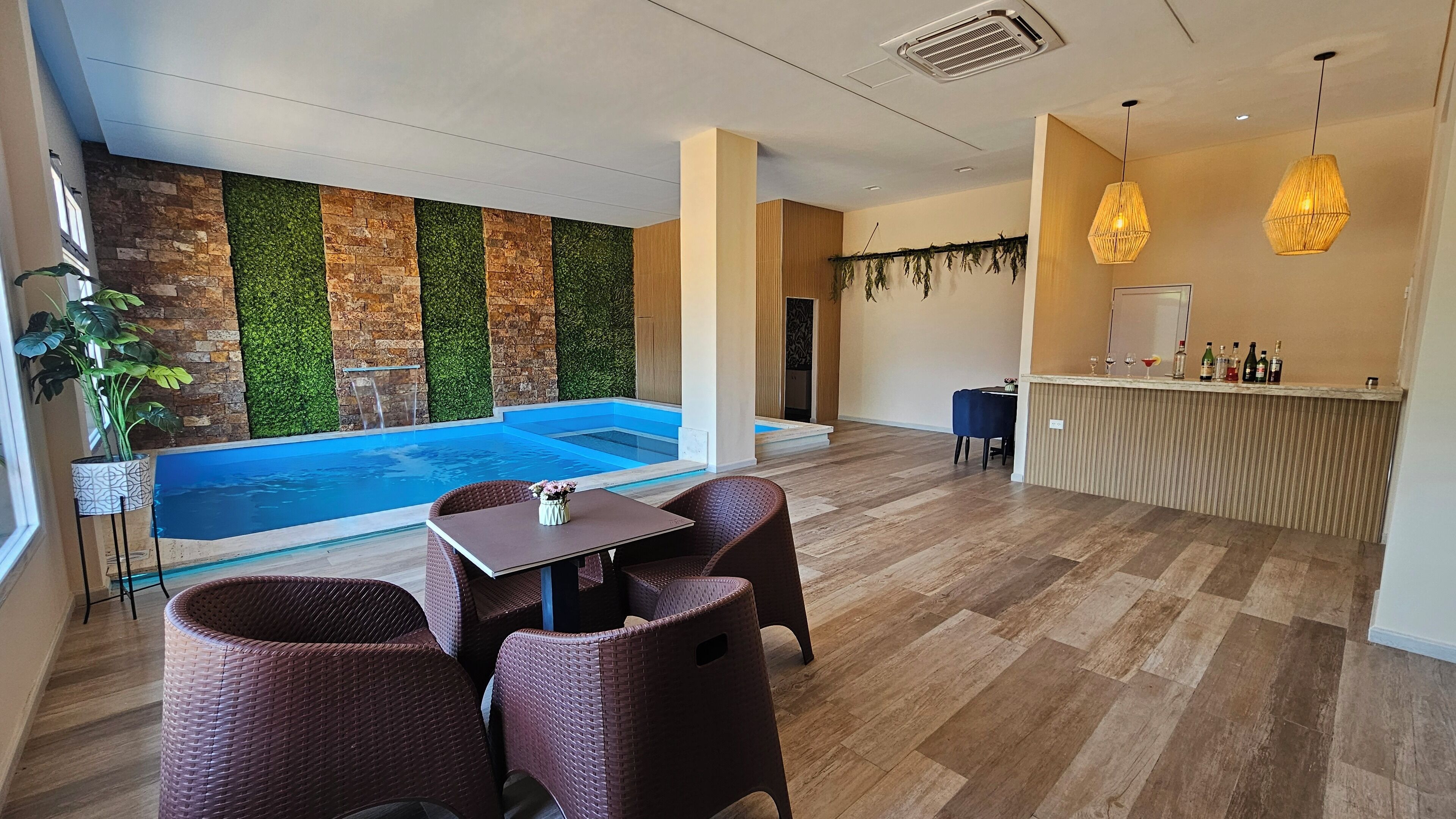 A modern indoor pool area with a bar and seating.