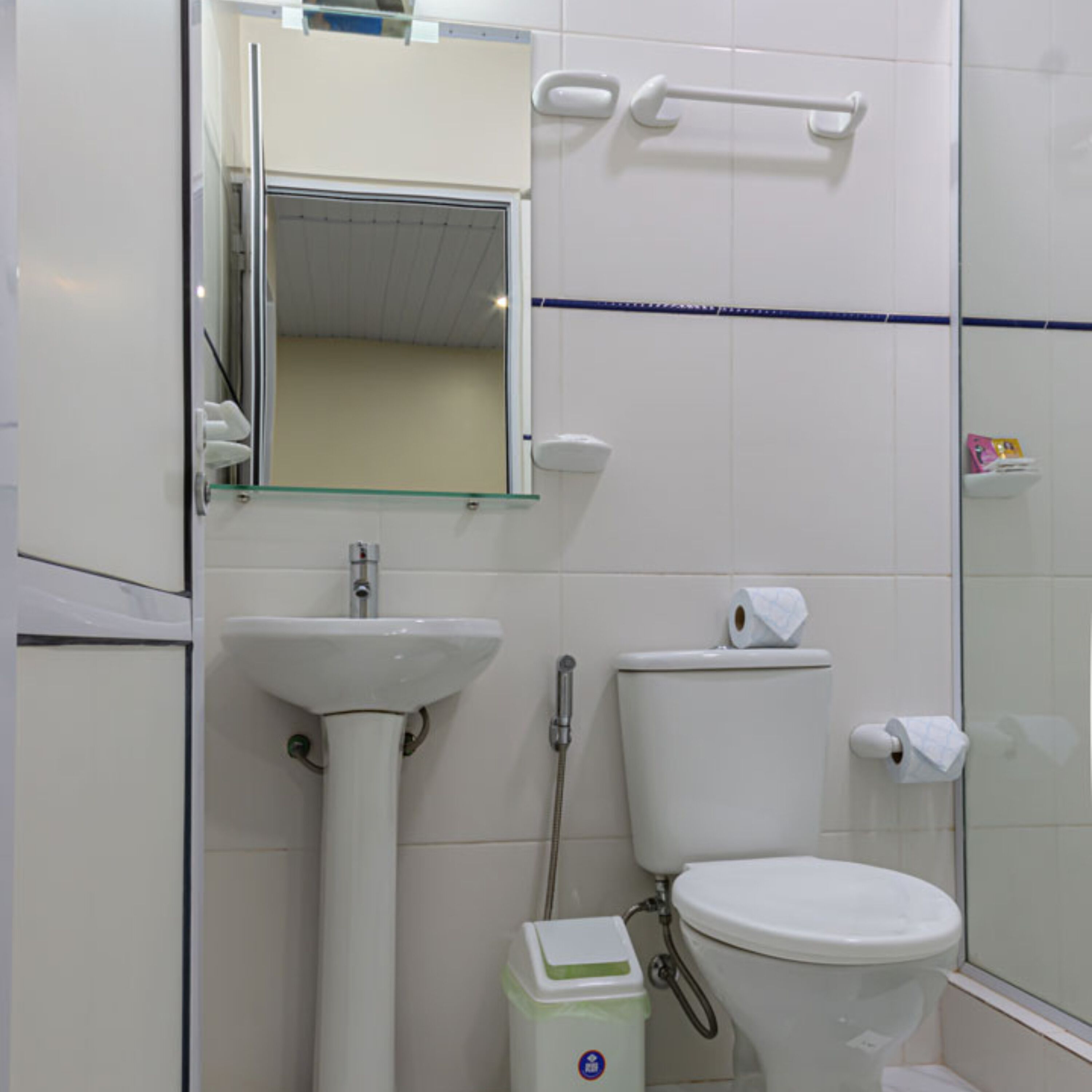A bathroom with a sink, toilet, and a glass shower enclosure.