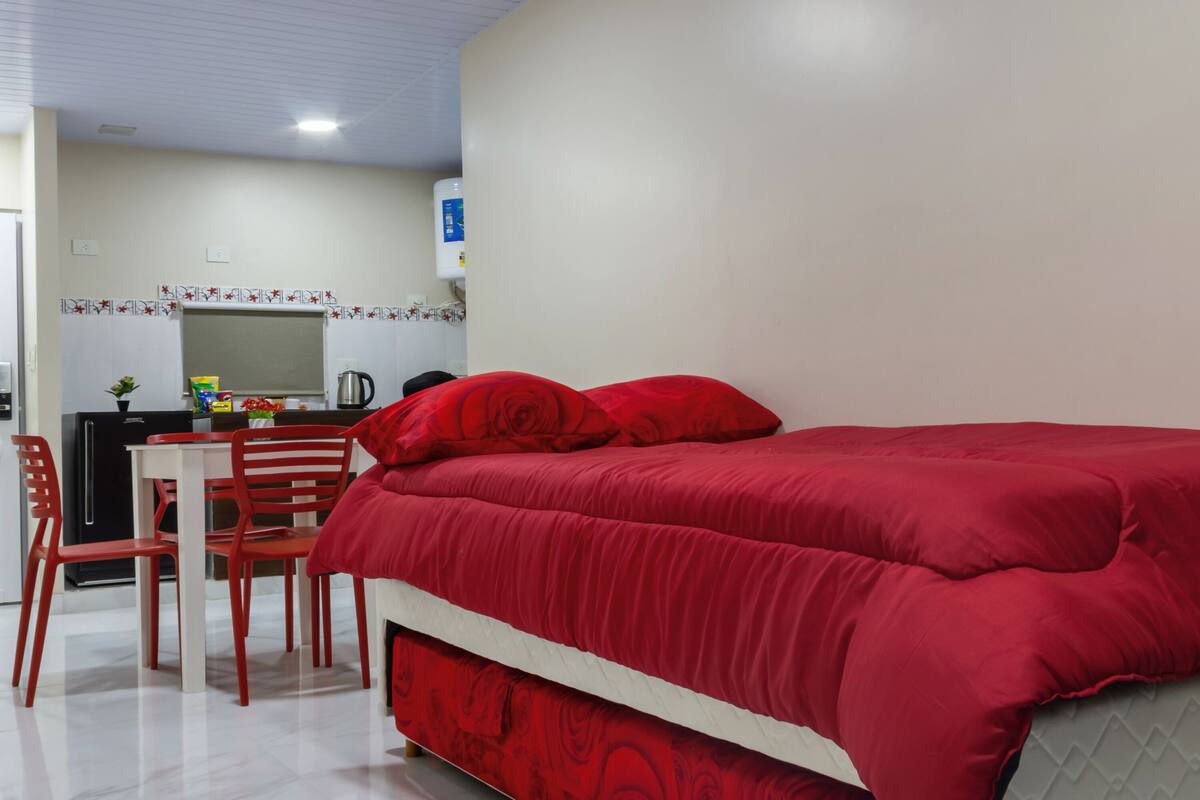 Ein Schlafzimmer mit Bett, Schreibtisch und Stühlen.