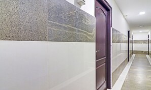 A hallway with a marble wall and a door with the number 401. - Itsy Hotels Aura Stays (Hyderabad)