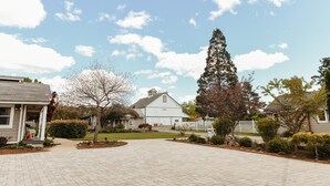 A residential area with a barn, paved driveway, and well-maintained lawns. - The Cottage: One bedroom w/mini fridge & private bath. (Medford)