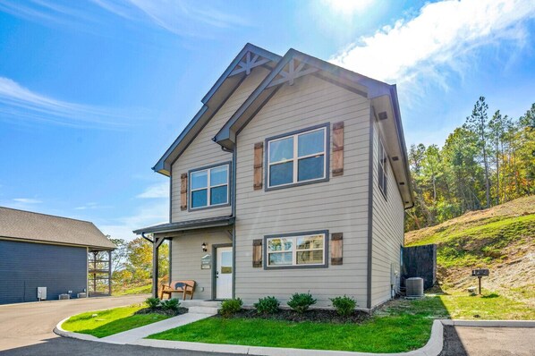 A two-story house with a gabled roof, a front porch, and a small front yard. - Modern 4BR Cabin ★ Amazing Location Near Dollywood ★ Grotto Hot Tub ★ Game Room (Sevierville)