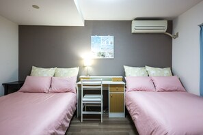 Une chambre avec deux lits, un bureau et un appareil de climatisation.