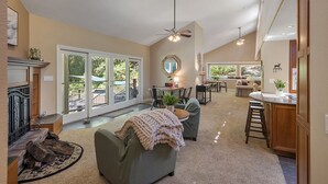 A spacious living area with a fireplace, a dining area, and a kitchen with a bar.