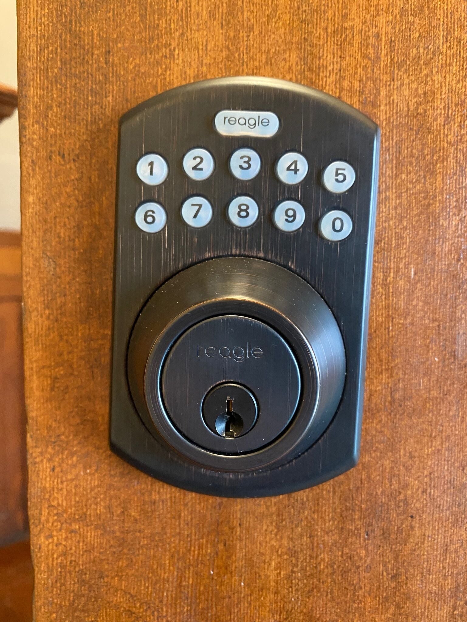 A black electronic keypad lock with a numeric keypad and a keyhole below it.