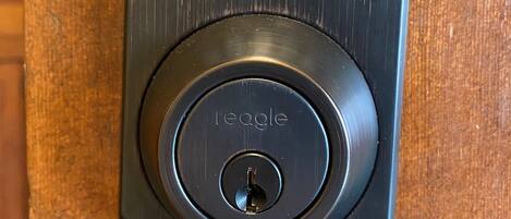 A black electronic keypad lock with a numeric keypad and a keyhole below it.