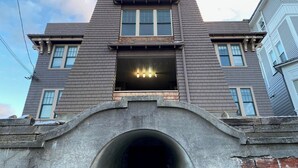 A two-story building with a central entrance and a small balcony.