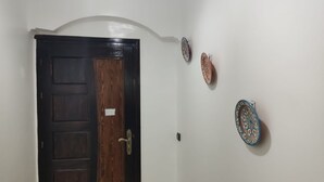 A room with a wooden door, a white wall, and three decorative plates.