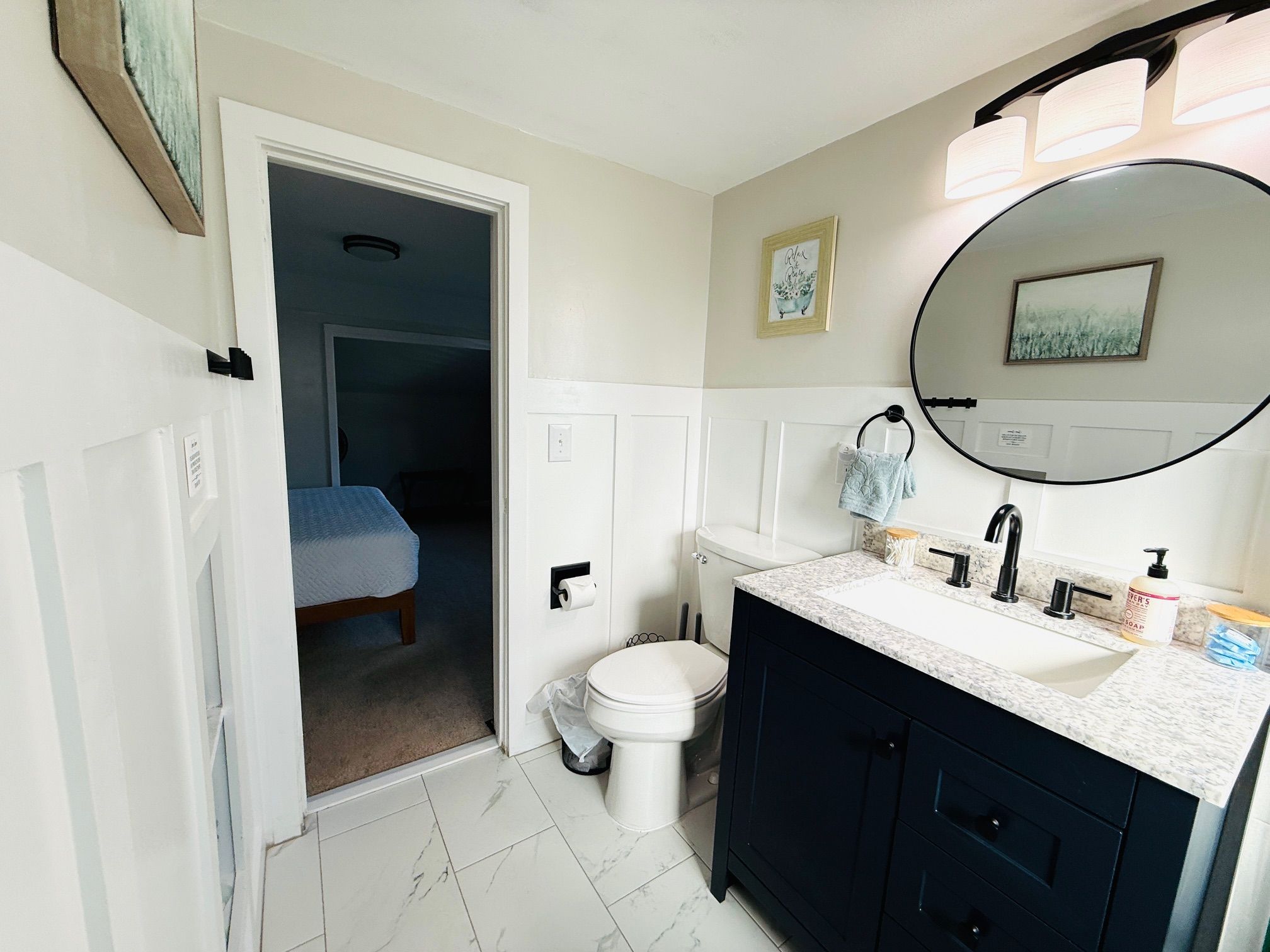 A bathroom with a toilet, sink, and mirror.