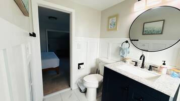 A bathroom with a toilet, sink, and mirror.