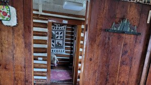 A wooden interior with a table and a patterned rug. - Historic Ft Wilderness Cabin (South Fork)