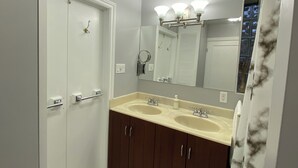 A bathroom with two sinks, a mirror, and a shower door.