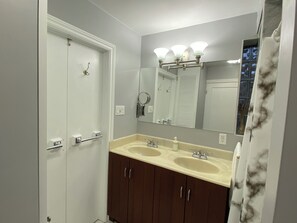 A bathroom with two sinks, a mirror, and a shower door.