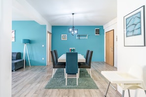 A dining area with a table, chairs, and a floor lamp.
