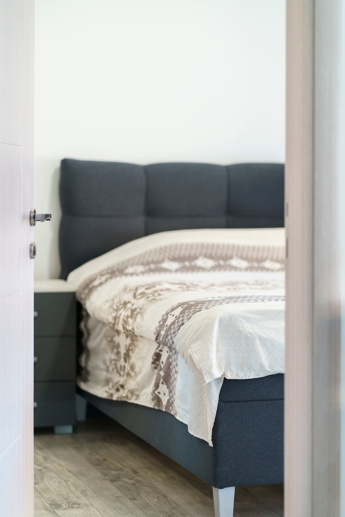 A bedroom with a bed, a bedside table, and a wardrobe.