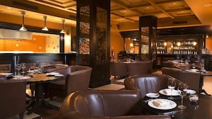Ein Restaurant mit Ledersitzgelegenheiten, einer Bar und einem modernen Deckenstil.
