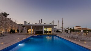 Una piscina con lettini da sole e una zona patio coperta.
