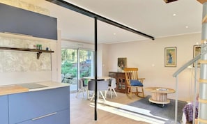 A modern interior with a kitchen, dining area, and a staircase.