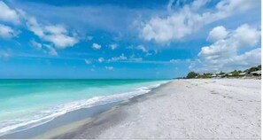 Ein Strand mit klarem türkisblauem Wasser und einem sandigen Ufer.
