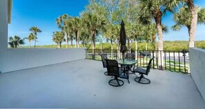 Enjoy a serene view from this balcony with a glass-top table and four chairs.