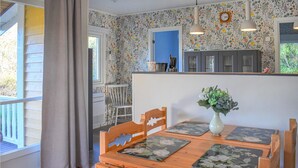 Ein Essbereich mit Holztisch, Stühlen und einem Blumenstrauß.