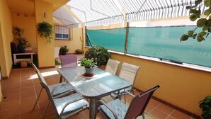 A balcony with a table and chairs, potted plants, and a view of the sea. - Relax & Home, Apartment with terrace and parking (La Zubia)