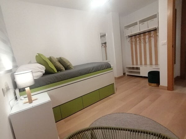 A bedroom with a bed, bedside table, lamp, and a wardrobe with hanging space. - Relax & Enjoy Home Life: Apartment with a Terrace and Parking Space (La Zubia)