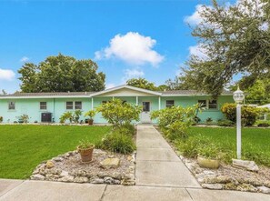 Stroll up to this charming home, featuring a front porch and a beautifully manicured lawn.