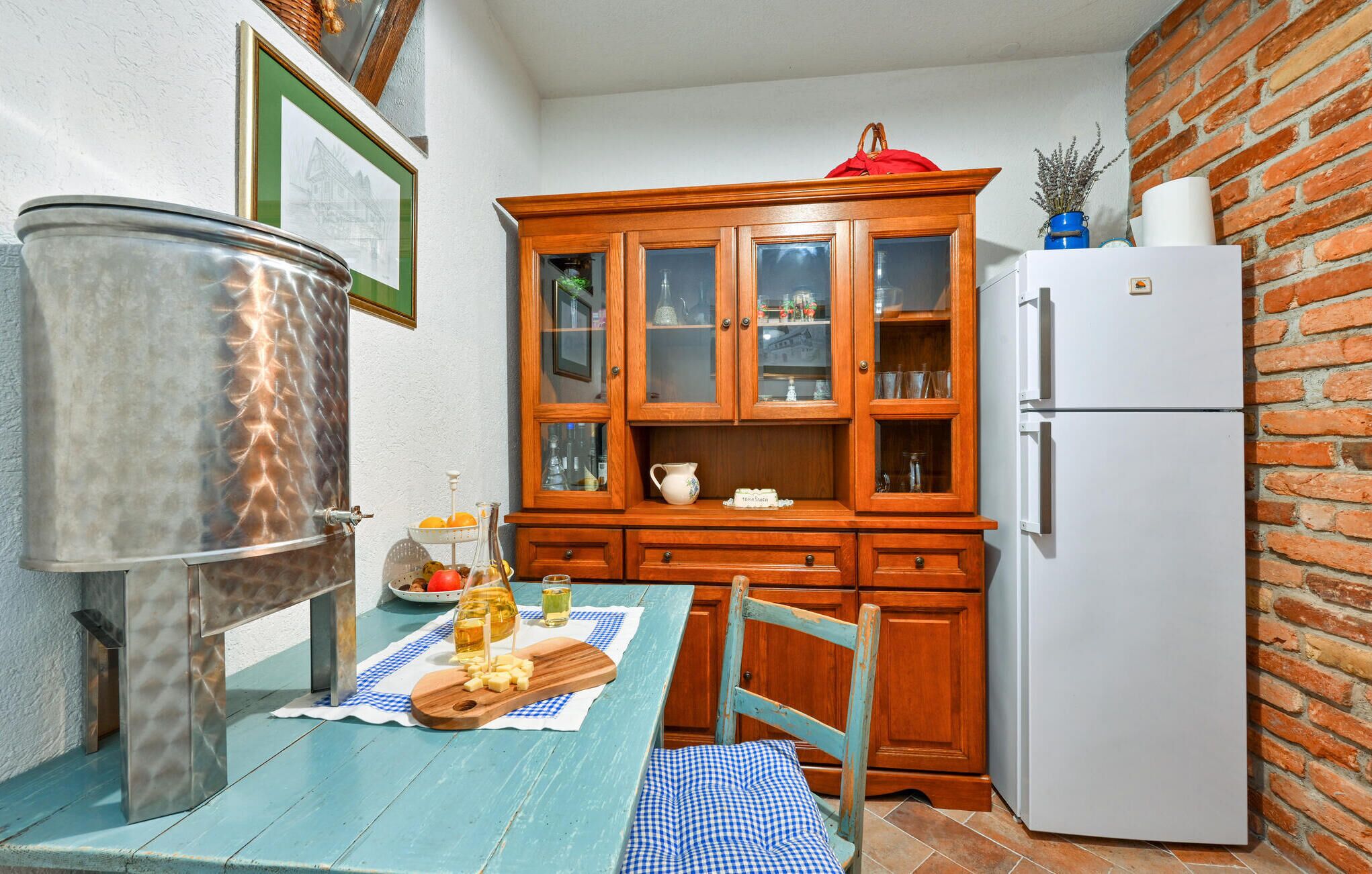 A compact kitchen with a wooden cabinet, a white refrigerator, and a metal stove.