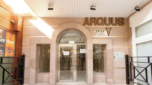 A hotel entrance with a name sign 'ARQUUS' and the address '29-33 V'.