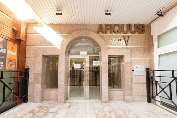 A hotel entrance with a name sign 'ARQUUS' and the address '29-33 V'.