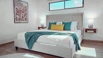 Un dormitorio con cama, mesitas de noche, una ventana y un cartel en la pared.