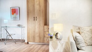 Una habitación moderna con un armario de madera, un escritorio de vidrio con una lámpara y una cama con un edredón texturizado.