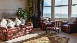 A living room with a sofa, armchairs, and a view of the water.
