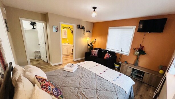A bedroom with a bed, bedside table, and a TV mounted on the wall. - Talavera- vibrant Mexican-inspired apt in Salem (Salem)