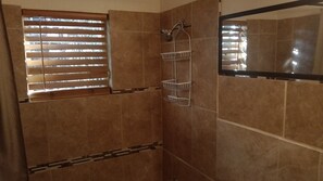 Een douche, handdoeken, zeep, toiletpapier