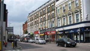A street with buildings, cars, and a bus. - Lovely Studio Apartment in London (London)