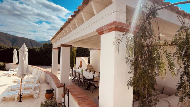 A covered outdoor seating area with a pergola, lounge chairs, and a dining table. - Grande Villa Dans les Vergers de Pêchers (Bouleternère)