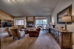 A cozy living room with a fireplace, comfortable seating, and a TV.