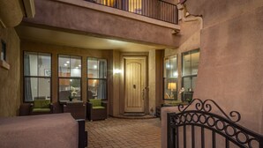 A hotel entrance with a wooden door, wicker furniture, and a wrought iron gate. - Heated pool, jacuzzi, Fast Wifi, Pac Man, Fire Pit, BBQ, Sleeps 14! (Phoenix)