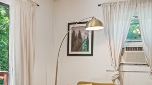 A cozy living room with a green sofa, a floor lamp, and a framed picture on the wall. - Outdoor Theatre | Hot Tub | Fire Pit | Dogs (Luray)