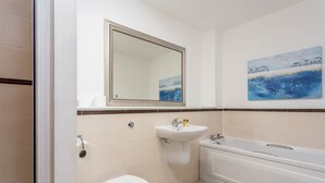 A bathroom with a toilet, sink, and bathtub. - No27 The Barclay - Donnini Apartments (Kilmarnock)