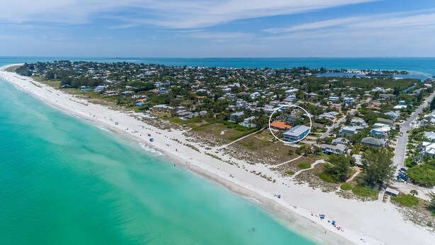 Vista aérea de una zona costera con playa, casas y una propiedad señalada.